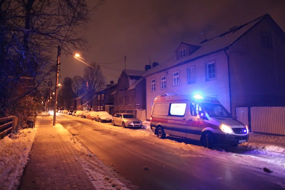 Una ambulancia con las luces azules encendidas en una calle nevada de noche