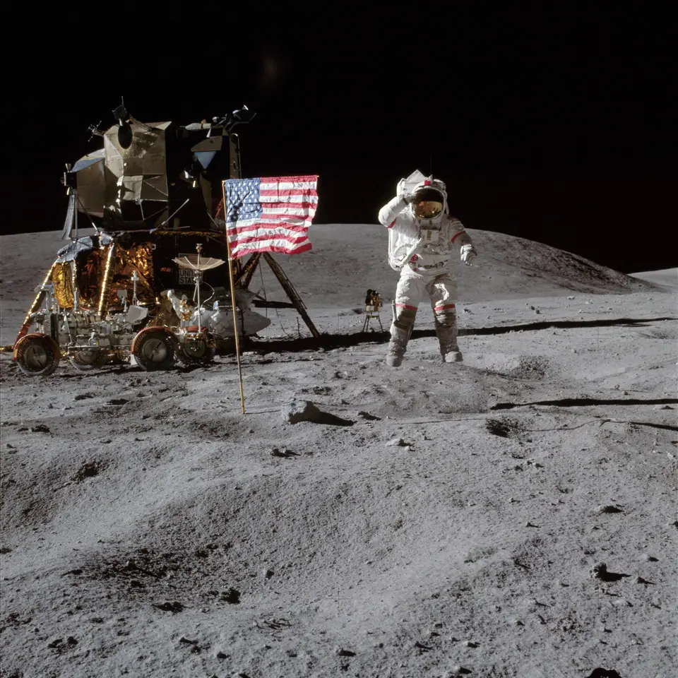 El astronauta John Young salta sobre la superficie de la Luna junto a la bandera y el módulo lunar durante la misión Apolo 16