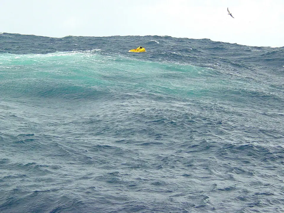 Balsa salvavidas amarilla entre olas en mar abierto, vista desde un buque cerca de Bermudas