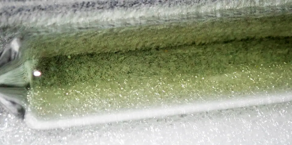 Ampolla de vidrio sellada con cloro gaseoso, de color verde amarillento