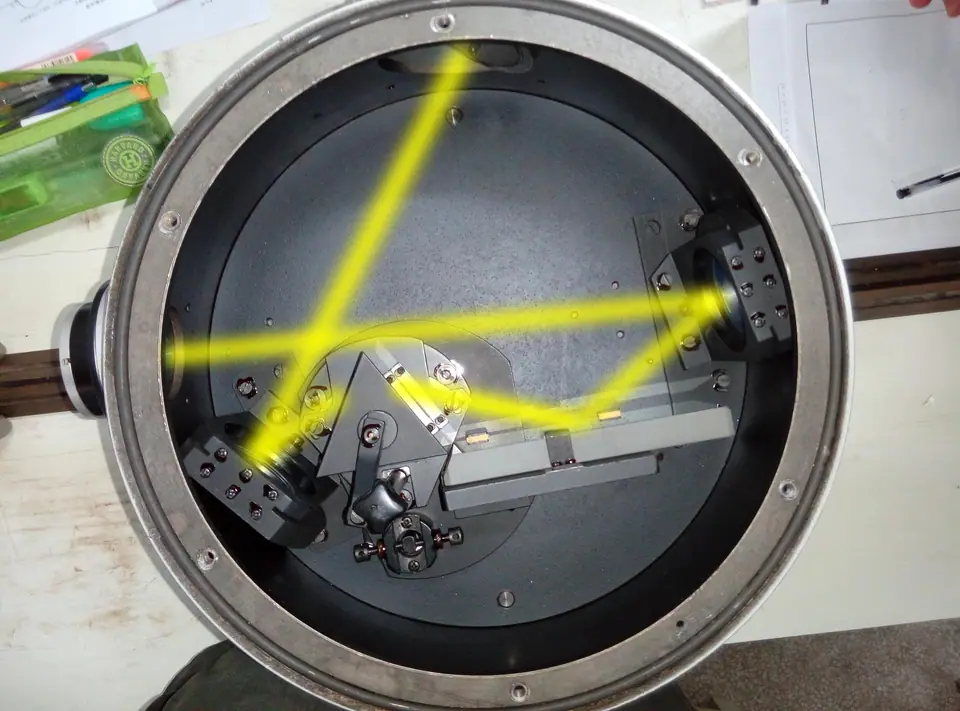 Un monocromador de prisma en un laboratorio, con el haz de luz amarilla dispersándose en el recorrido óptico