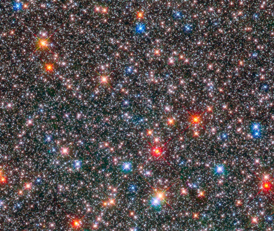 Miles de estrellas de colores apiñadas en el bulbo central de la Vía Láctea, fotografiadas por el telescopio Hubble