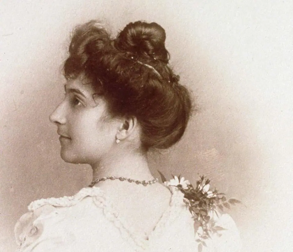 Retrato en sepia de Jeanne Calment a los 20 años, de perfil, con el pelo recogido, hacia 1895