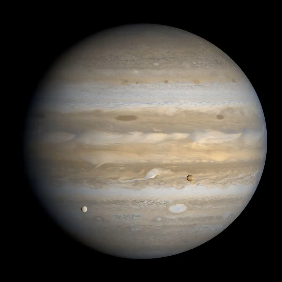 Júpiter fotografiado por la sonda Voyager 1 en 1979, con sus lunas Ío y Europa delante del disco del planeta