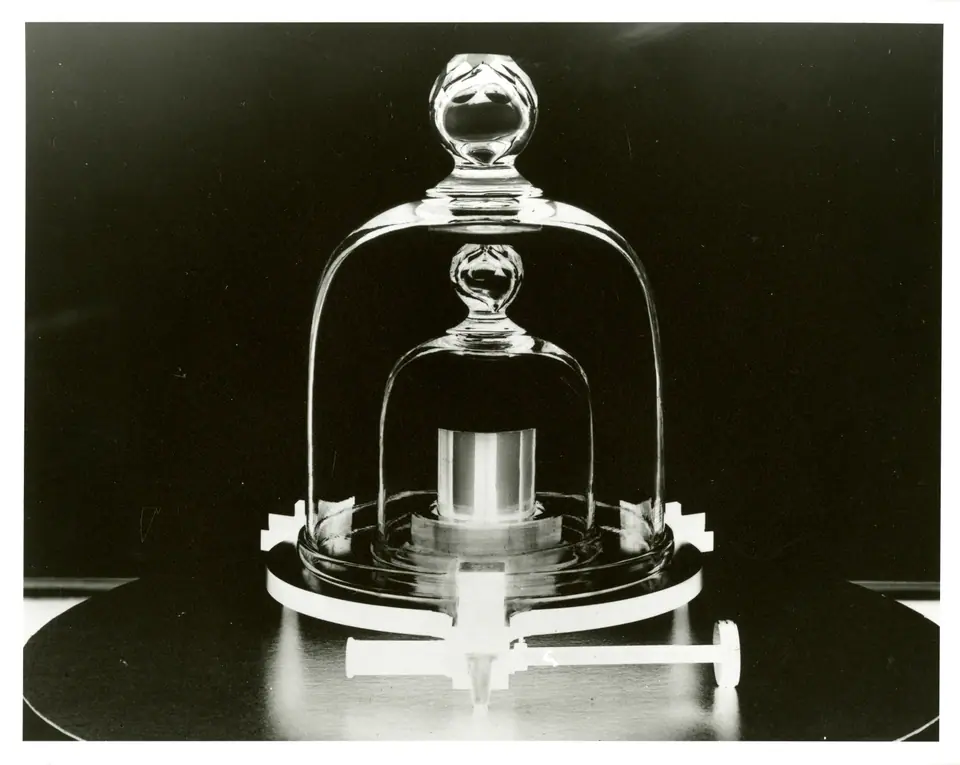 Réplica del prototipo del kilogramo: un cilindro metálico bajo dos campanas de vidrio, en una foto del NIST de Estados Unidos